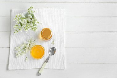 Tatlı bal ve akasya çiçekli kompozisyon açık ahşap arka planda