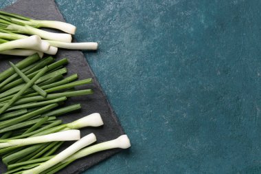 Mavi zemin üzerinde taze yeşil soğan olan tahta