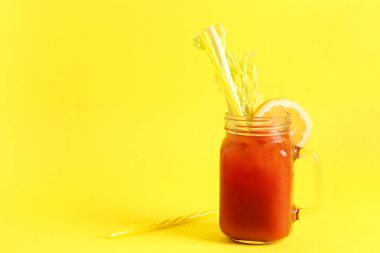 Sarı zemin üzerinde kereviz ve limon olan bir kavanoz Bloody Mary.