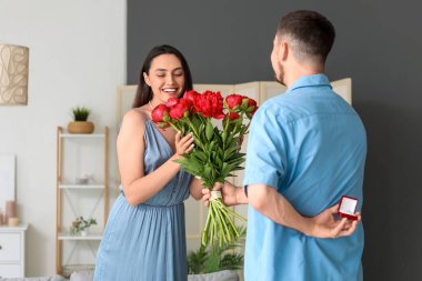 Çiçekli genç adam kız arkadaşına evlenme teklif ediyor.