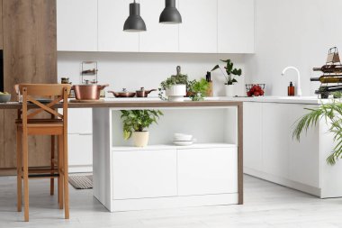 Ada masası ve beyaz tezgahlı modern mutfak.