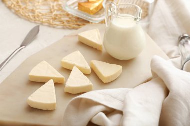 Hafif arka planda lezzetli işlenmiş peynir ve süt üçgenleri olan pano, yakın plan.