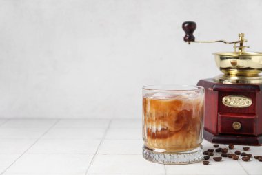 Sütlü ve öğütücülü bir bardak buzlu kahve.