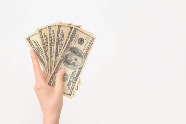 Beyaz arka planda 100 dolarlık banknotlar tutan kadın.