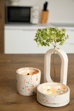 Ortanca çiçekleri ve yanan mumlar açık mutfakta, yakın plan.