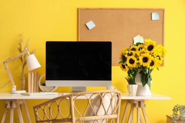 Ofisinde bilgisayar ve ayçiçekli modern işyeri