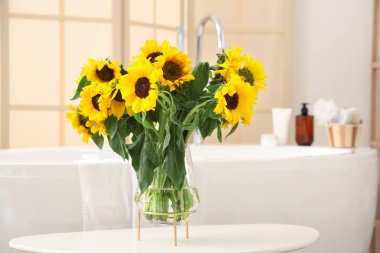 Banyo masasında ayçiçekli vazo, yakın plan.