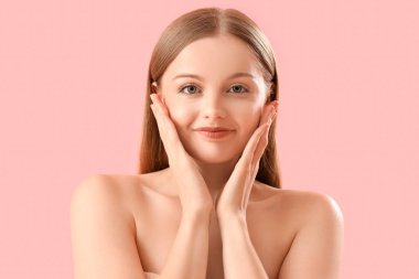 Pembe arka planda gülümseyen güzel bir genç bayan. Cilt bakımı kavramı
