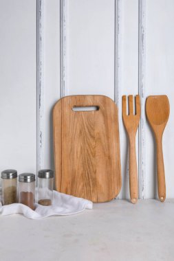 Hafif arka planda ahşap mutfak aletleri ve baharatlar