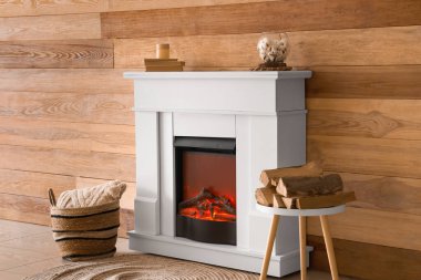 Kaliteli şömine, odun ve sepet, yumuşak yastık, ahşap duvarın yanında.