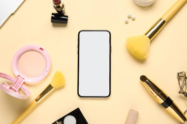 Renkli arka planda modern cep telefonu, dekoratif kozmetik ve makyaj aksesuarları ile kompozisyon