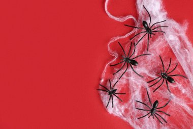Kırmızı arka planda Cadılar Bayramı partisi için örümceklerle örümcek ağı
