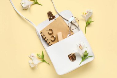 Renkli arka planda kadın çantalı, aksesuarlı ve çiçekli kompozisyon