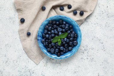 Taze yaban mersinli kase ve beyaz arka planda nane.