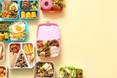 Sönük sarı arka planda farklı lezzetli yemekleri olan bir sürü beslenme çantası.