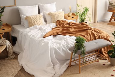 Rahat yataklı ve gri banklı rahat yatak odasının içi