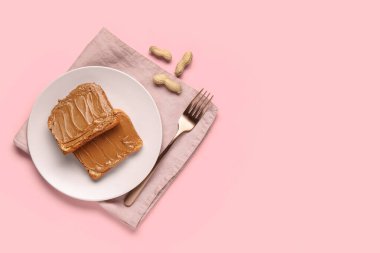 Pembe arka planda fıstık ezmeli tost tabağı