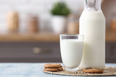 Mutfaktaki mavi masada tatlı kurabiyeli bir bardak taze süt.