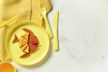 Beyaz masada balık şeklinde komik çocuk kahvaltısı tabağı.