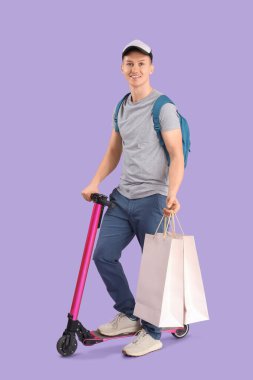 Alışveriş torbalı erkek kurye ve leylak arka planda scooter.