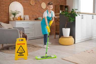 Evinde uyarı levhası paspaslama yeri olan genç hademe.