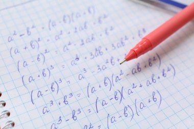 Matematik denklemleri ve kalemle yazılmış defter, kapat