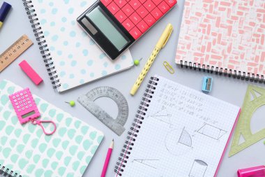 Gri arkaplanda hesap makinesi ve okul kırtasiyesi