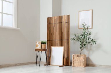 Zeytin ağacı, sehpa, resim ve katlanır ekran olan bir oturma odası.