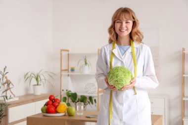 Ofisinde lahana olan kadın beslenme uzmanı.