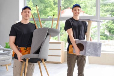 Şık bir odada sandalyeler taşıyan yükleyiciler