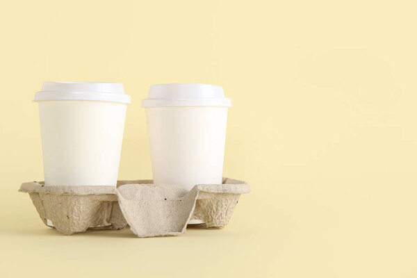 White takeaway paper cups with holder on beige background