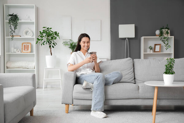 Diabetic young woman with glucose sensor and mobile phone measuring blood sugar level at home