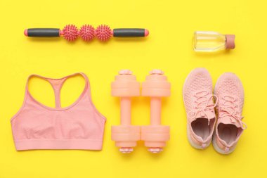 Sarı arka planda spor aletleri ve giysiler.