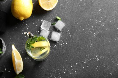 Siyah arka planda naneli ve buzlu bir bardak limonata.