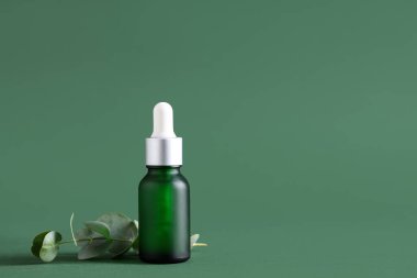 Yeşil arka planda bir şişe okaliptüs esaslı yağ