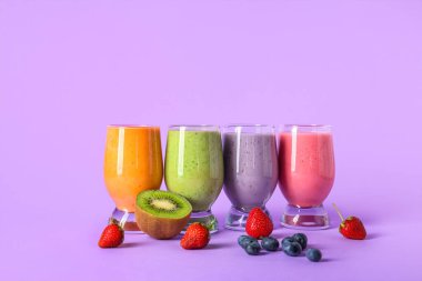 Leylak arka planında farklı meyveler olan taze meyve püresi.