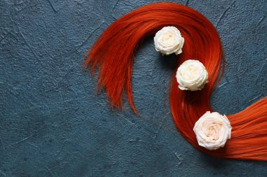 Koyu renk arka planda gül çiçekleri olan kırmızı saç teli.