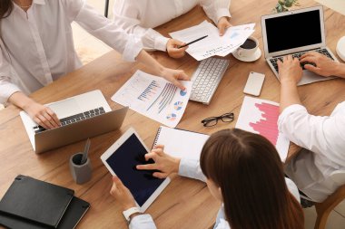 Ofisteki toplantı sırasında tablet ve dizüstü bilgisayarlarla çalışan iş ekibi, yakın çekim