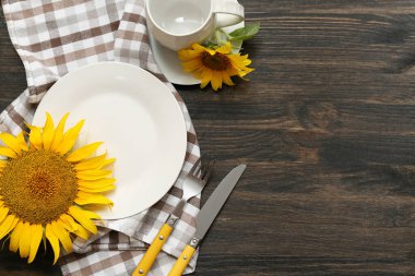 Koyu ahşap arka planda ayçiçekleri olan güzel bir masa.