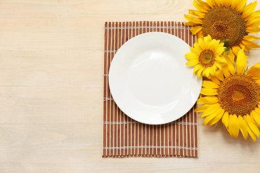 Bej ahşap arka planda ayçiçekleri olan güzel bir masa.