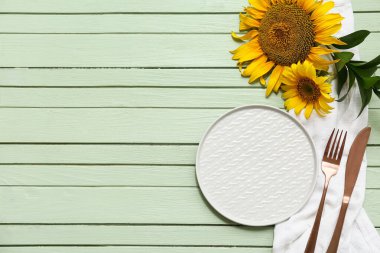 Yeşil ahşap arka planda ayçiçekleri olan güzel bir masa.