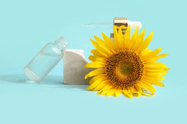 Gerekli yağ şişesiyle kompozisyon ve renk arkaplanda güzel bir ayçiçeği