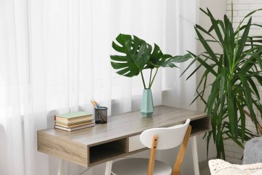 Masada tropikal canavar yaprakları olan modern bir oturma odası.