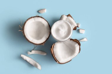 Mavi arka planda hindistan cevizi kozmetik kremi kavanozu