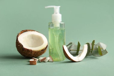 Yeşil arka planda bir şişe hindistan cevizi kozmetik ürünü ve okaliptüs.