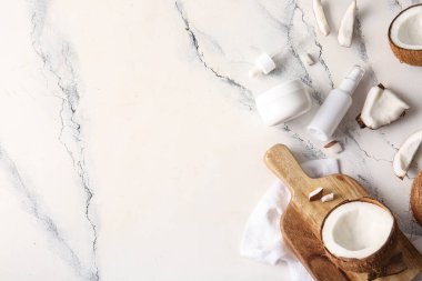 Beyaz arka planda kremalı bir şişe hindistan cevizi kozmetik yağı ve kavanoz