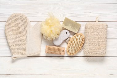 Beyaz ahşap arka planda farklı banyo malzemeleri.