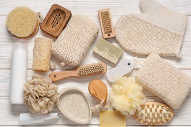 Beyaz ahşap arka planda farklı banyo malzemelerine sahip kompozisyon