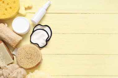 Renkli ahşap arka planda farklı banyo malzemeleri ve kozmetik ürünleri içeren kompozisyon