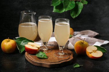 Siyah arka planda gözlük ve bir sürahi taze elma kvass.